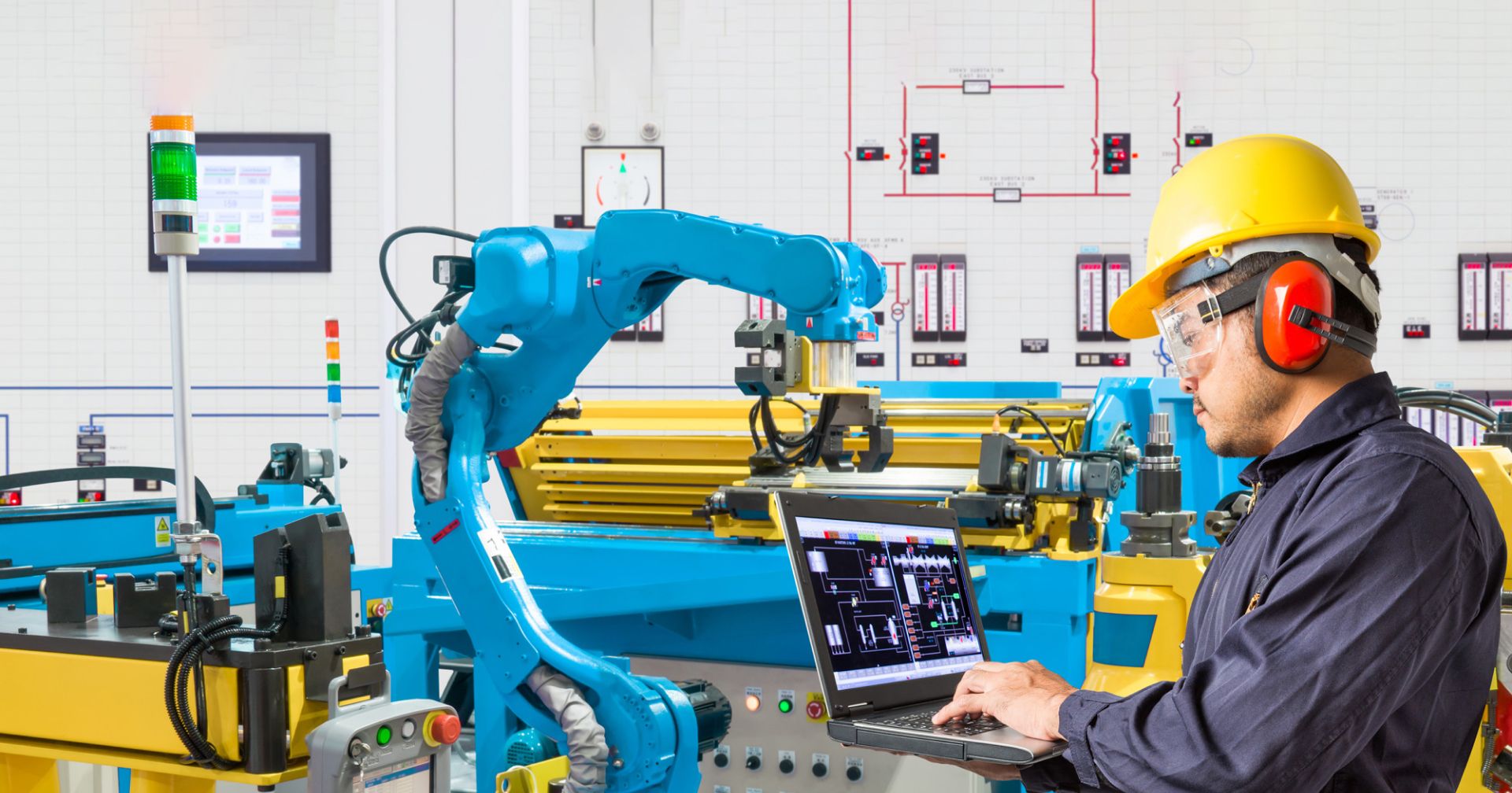 Photo of a manufacturing company with a worker holding a laptop